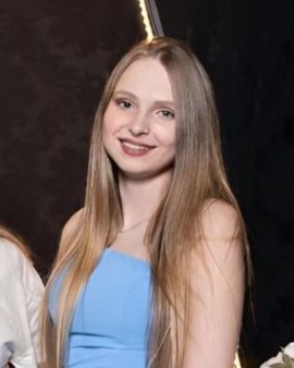 Évelyn Daiane, integrante da equipe Infotec, sorrindo, com cabelo longo e vestido azul-claro.